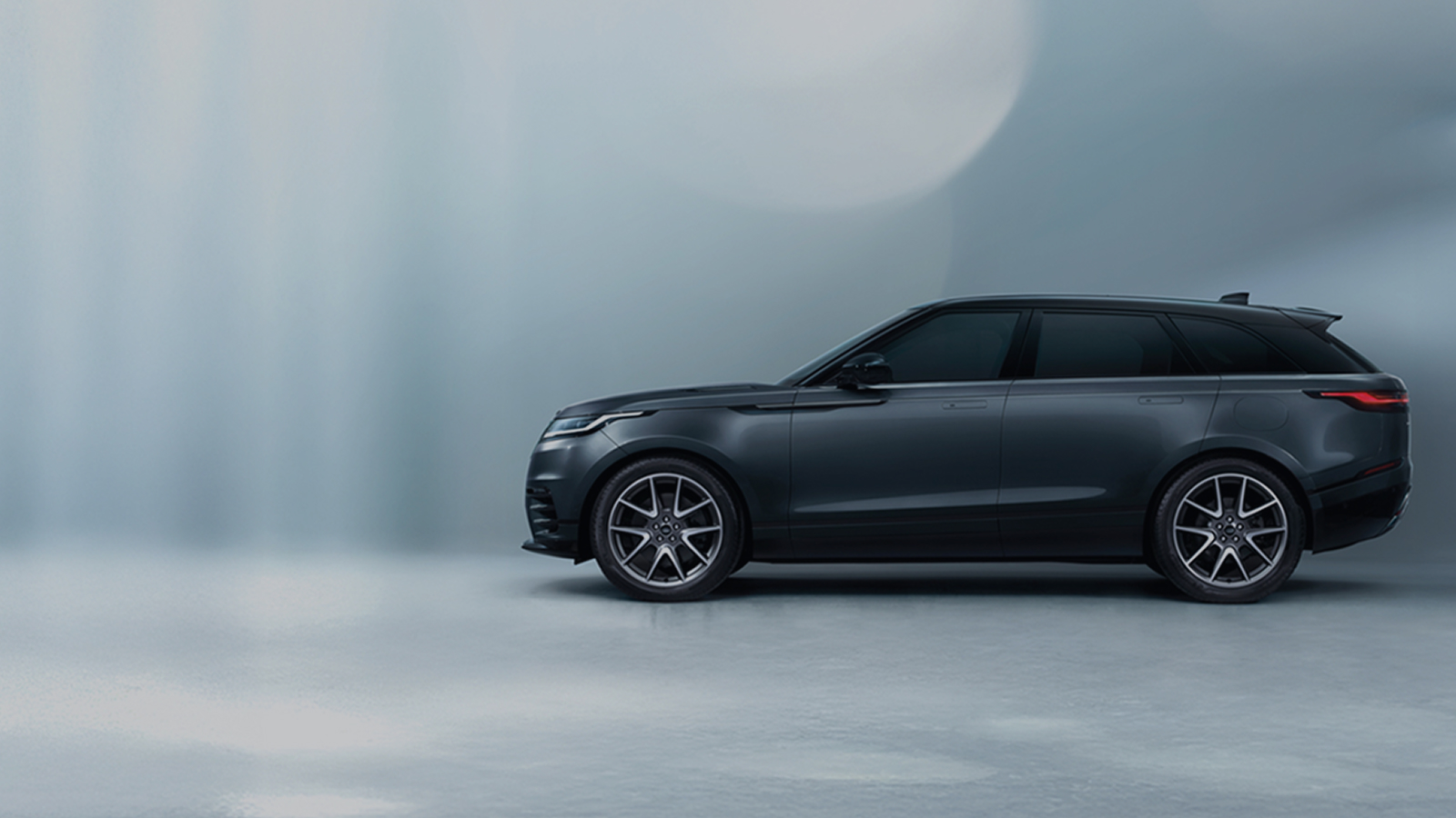 Side view of a blue Velar with promotional text overlay stating 'Up to £4,490 savings and 6.9% APR'.