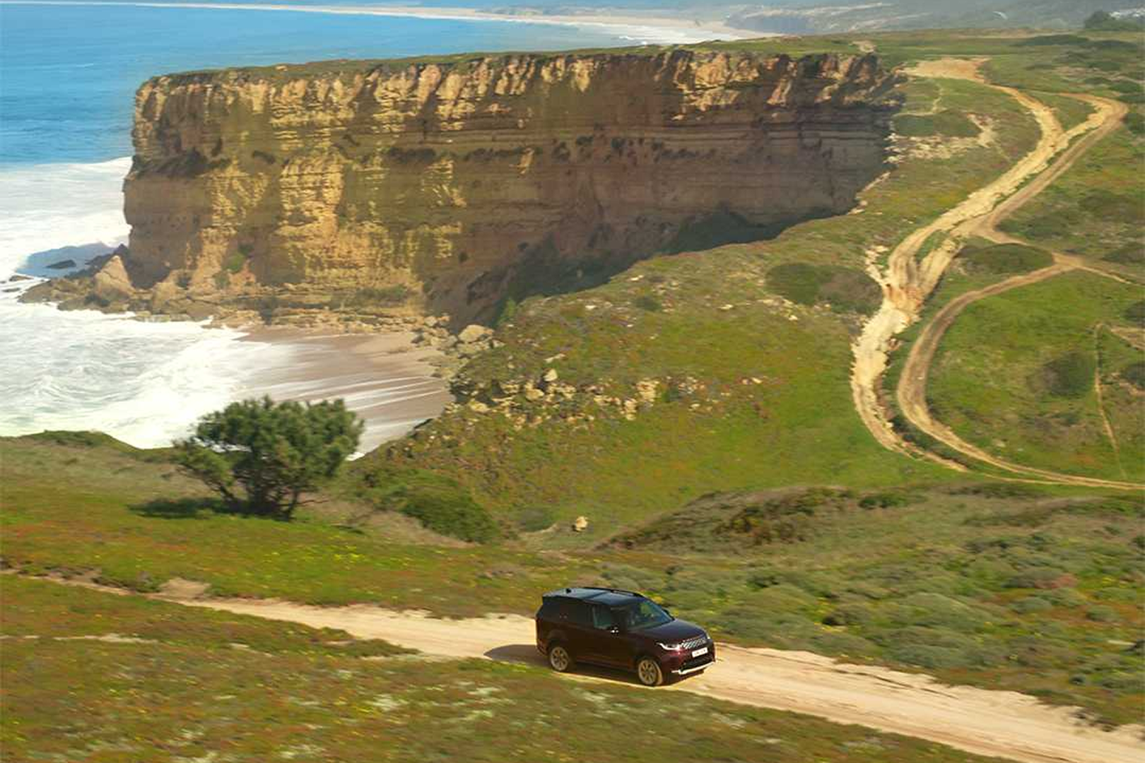 Range Rover driving away from a beach.