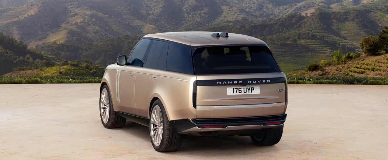 The rear of a Range Rover against a scenic country backdrop